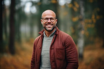 Handsome middle-aged man with glasses in the autumn forest
