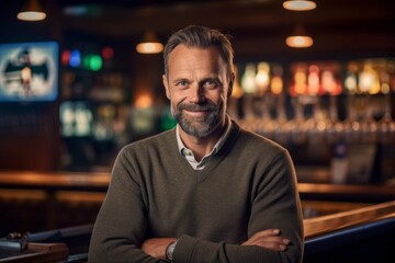 Portrait of handsome mature man standing with arms crossed at bar counter