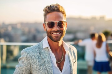 Portrait of a handsome young man in sunglasses on the roof of a skyscraper