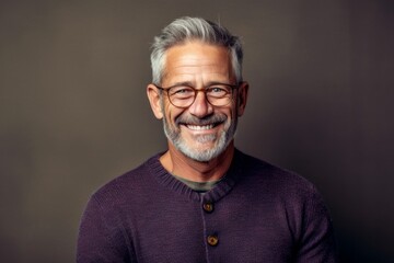 Obraz premium Portrait of a handsome mature man with eyeglasses on grey background