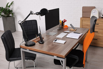 Stylish director's workplace with comfortable furniture, computer and accessories in office. Interior design