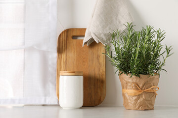 Aromatic green rosemary in pot on white table