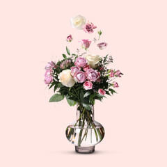 Beautiful bouquet in glass vase and flying flowers on beige background