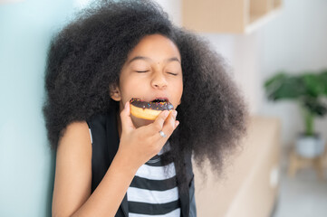 Fototapeta na wymiar African American girl eating donut