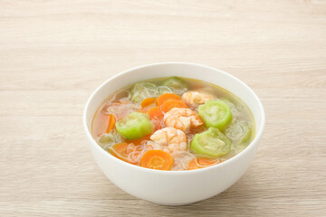 Sayur Oyong Bihun, made from luffa acutangula, carrot, shrimp and vermicelli. Served in white bowl
