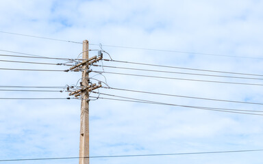 Photo of concrete electric power pole with sky in the background.