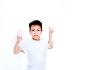 A happy little boy in a blue T-shirt is pointing and laughing on a blue background. Copy a place for your text