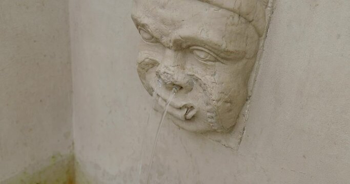 Water Flowing From Nose Of A Face Carving At The Fountain In Mantua, Italy. closeup