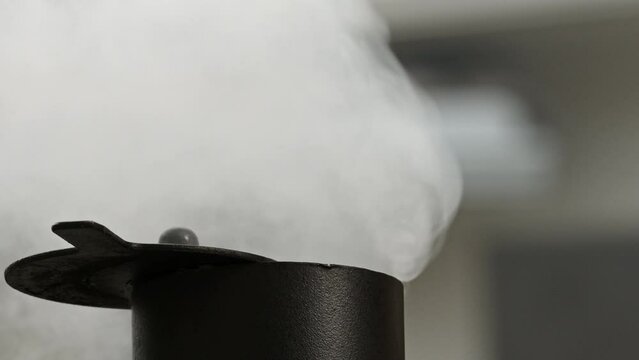 Macro close up of smoke rising from offset BBQ smoker chimney in slow motion