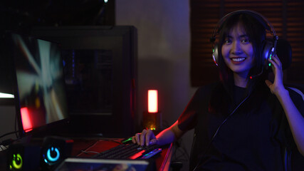Female cyber hacker gamer in headphone playing games or hacking programming system in neon light