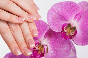Obraz na płótnie Canvas French manicure and orchid flower