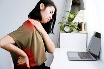 Asian Woman suffering Neck, Shoulder, and Lower Back Pain due to Office Syndrome from Prolonged...