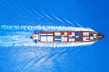 Aerial top view of cargo maritime ship with contrail in the ocean ship carrying container and running for export concept technology freight shipping. - obrazy, fototapety, plakaty