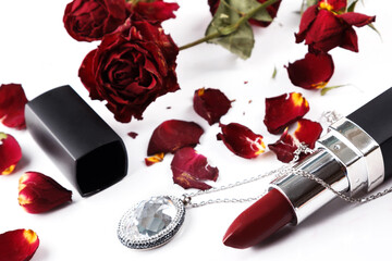 Obraz na płótnie Canvas Closeup of lipstick and dried rose flowers
