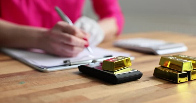 Financier broker puts gold bars on scales and weighs. Density and weight of gold bar
