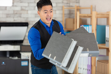 busy man with many folders falling at work