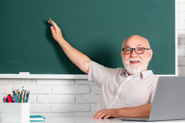 Portrait of senior teacher in classroom. Back to school. Learning concept. Education and knowledge. Middle aged professor, teacher on blackboard. Bearded professor teacher. Teachers day.