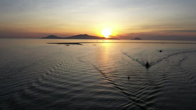 Fishermen throwing fishing net during dawn with boats at the sea gate. Concept Fisherman's life style. Cua Dai, Hoi An, Asia, Vietnam.