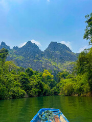 Blue canoe kayak with green mountains in the background, Thakhek loop, Laos
