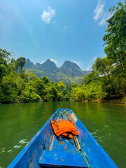 Blue canoe kayak with green mountains in the background, Thakhek loop, Laos
