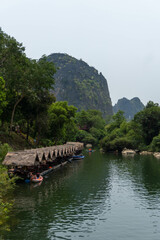 Luxurious mountain with vegetation and a lake with wooden hut, Thakhek loop, Laos