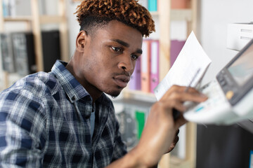 man reading instructions to repair photocopier