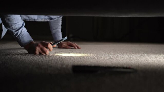 Young man lost and found remote control under couch.