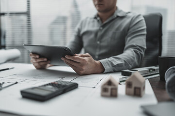 Architect, Engineering working with house drawings inspection on tablet in the office. Engineer, Architect, Industry and factory concept.
