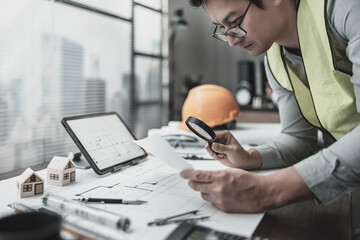 Architect, engineer hold magnifying glass to find and planning and drawing on city map and marking ...