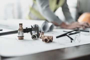 Engineering working with drawings inspection on the office desk  safety glasses, compass, vernier caliper on Blueprint. Engineer, Industry and factory concept.