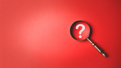 Magnifying glass and question mark icon symbol on red paper background with copy space. Problem solving troubleshooting education concept. - obrazy, fototapety, plakaty