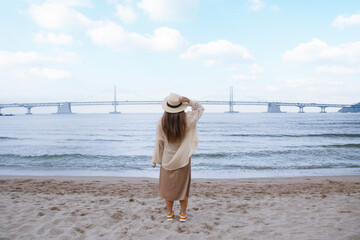 Woman traveller is sightseeing and looking at Gwangalli Beach in Busan, South Korea. 