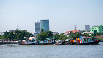 View on the buildings on the shore of the Chao Phraya river, from a boat (cruise) in Bangkok, Thailand.