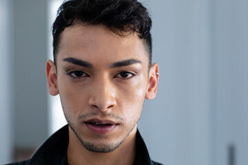 Fototapeta premium Portrait of biracial transgender man wearing biker jacket, looking at camera