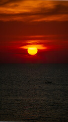 Vibrant dramatic orange sunset, dark water in Koh Lanta, Thailand