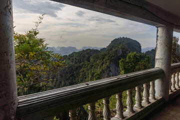 Landscape view on mountains and fields with vegetation, from an old rusty balcony in Tiger Cave Temple (Wat Tham Suea) in Krabi, Thailand.