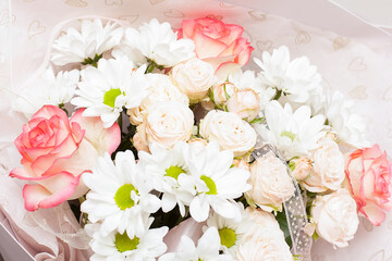 Girl's hands holding beautiful flowers bouquet: bombastic roses, blue eringium, eucalyptus, isolated on white background. Flat lay, top view. Floral composition.