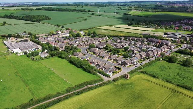 Aerial drone footage of the village of Great Houghton in the Metropolitan Borough of Barnsley in South Yorkshire, England showing the beautiful village and farmers fields on a sunny summers day.