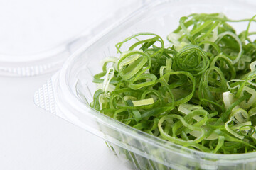 プラスチックケースに入ったカットネギ