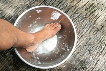 Male feet in a container of warm water to reduce injuries from accidents in the home