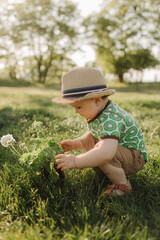 Summer sunny day for little boy became joyful and happy. Happy little boy playing outdoor in beautiful summer scenery. Happy childhood concept photo.