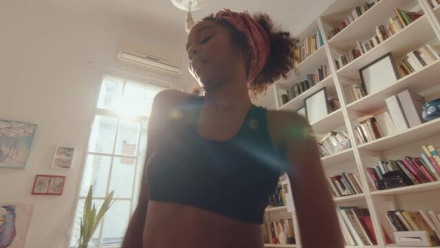 Young Energetic Black Girl Dancing To The Music In A Sunlit Living Room, Enjoying The Rhythm, Having Fun At Home. Whip Zoom Shot