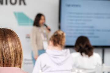 Anonymous woman listening to lecture with other students