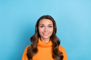 Fototapeta premium Photo of cheerful dreamy woman dressed orange sweater looking up empty space isolated blue color background