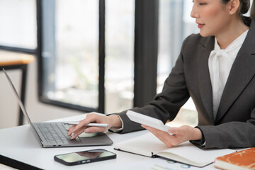 Young Asian businesswoman working on documents at office