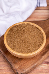 Coriander powder on wooden background. Powdered dried Coriander in wooden bowl