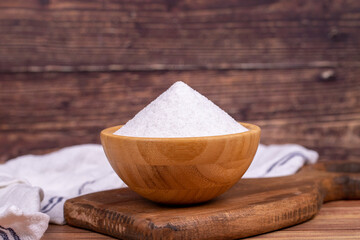 Natural minaret crystal non-iodized grinding salt on wooden background. Ground rock salt in wooden bowl