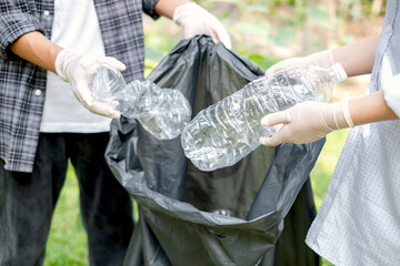 garbage collection, volunteer team pick up plastic bottles, put garbage in black garbage bags to...