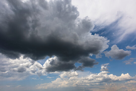 Blue sky with dark gray cumulus clouds background overlay. Ideal for sky replacement	
