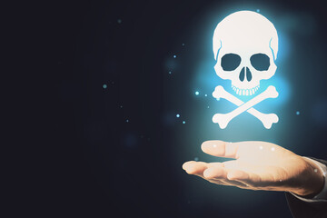 Close up of hand holding glowing white skull hologram on dark background with mock up place for your text. Cyber attack and malware concept.